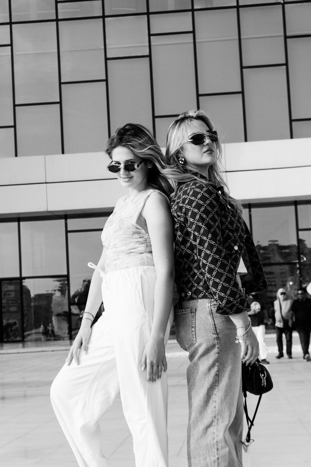 two-stylish-women-posing-back-to-back-outdoors-hezvhd5va1a
